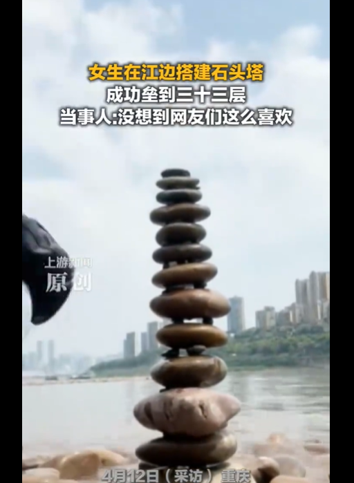 女生在江边搭石头塔垒到三十三层 这创意很赞